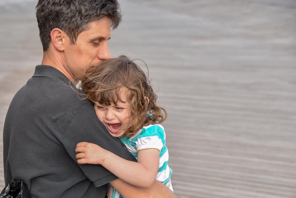 niña angustiada, llantos, regazo del padre, rabietas