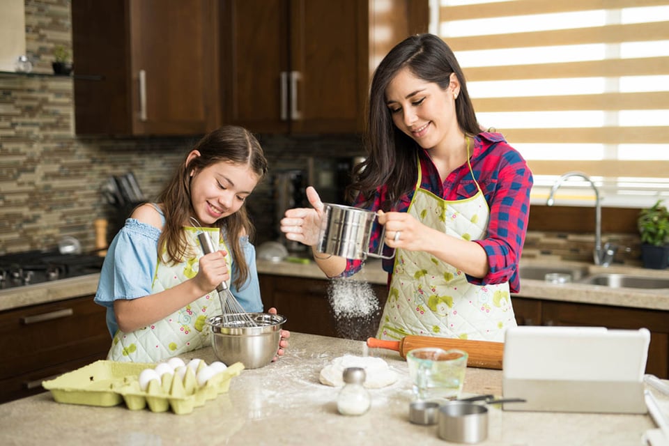 Madre hispana, tamizando harina, cocina, hija, mezclando masa