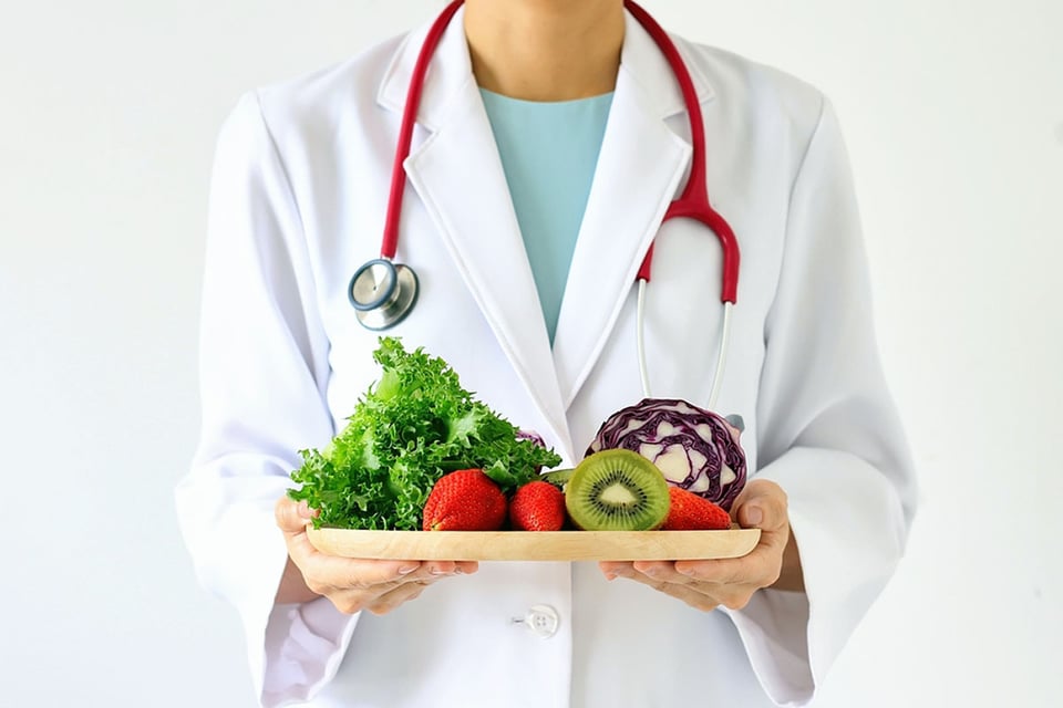 Doctora sosteniendo un plato de comida nutritiva