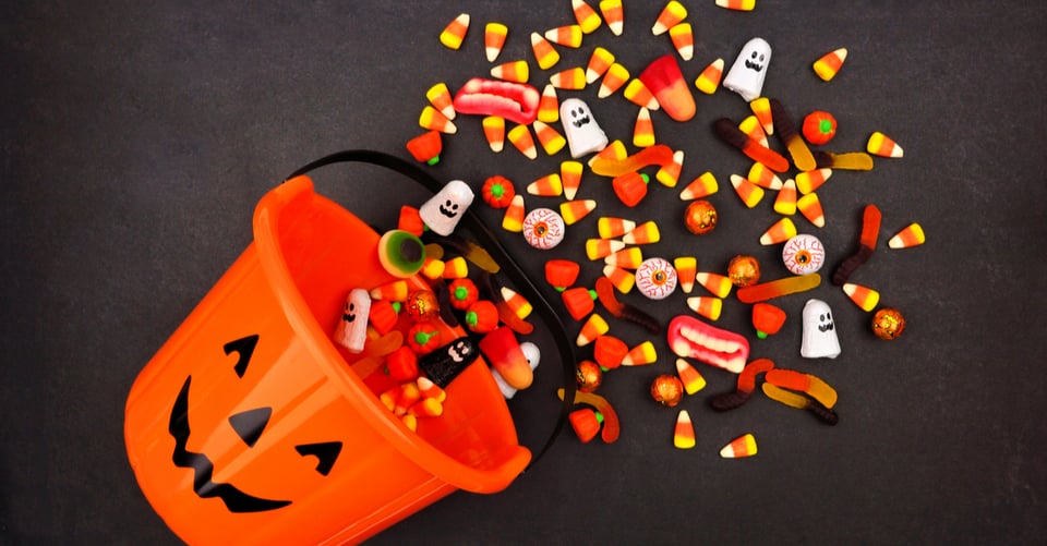 Dulces junto con bolsa de calabaza en el piso