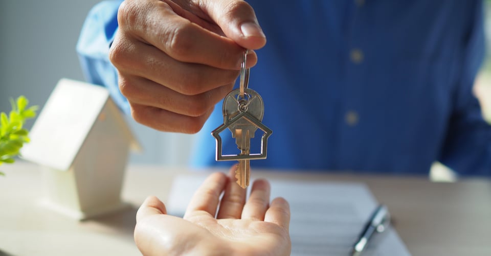Persona entregando llavero como idea de renta de vivienda