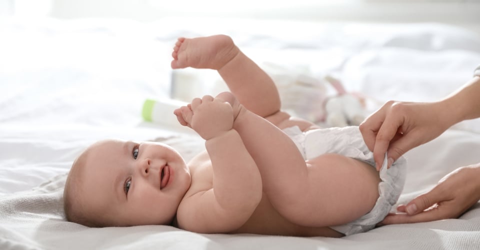 Un bebé con los pies arriba, que son el lugar para el tamiz