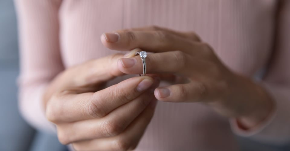 Mujer quitándose sortija como idea de infidelidad
