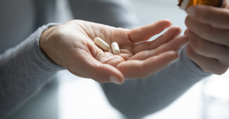 Persona con cápsulas que pueden ser para la gripe