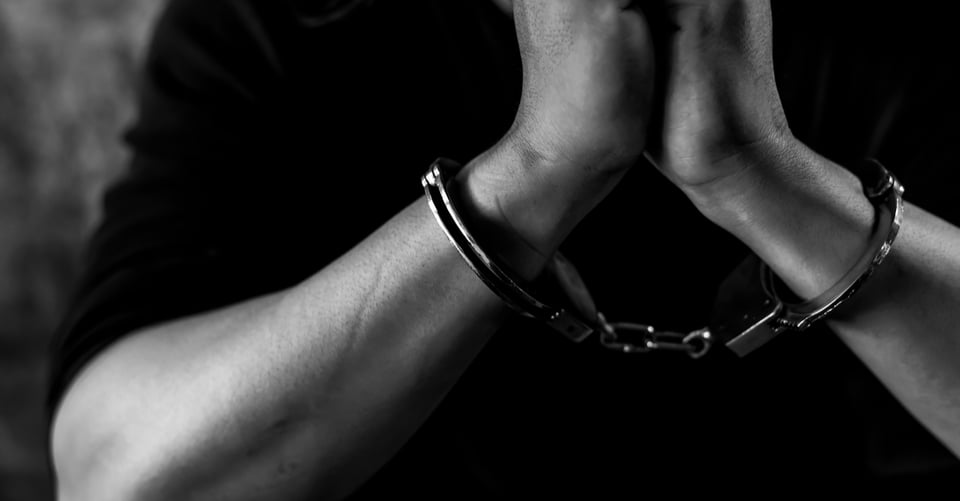 The hands of a murderer in handcuffs