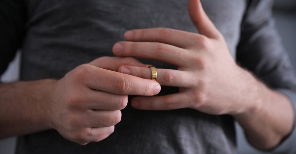 Persona retirando anillo de casado como idea de infidelidad