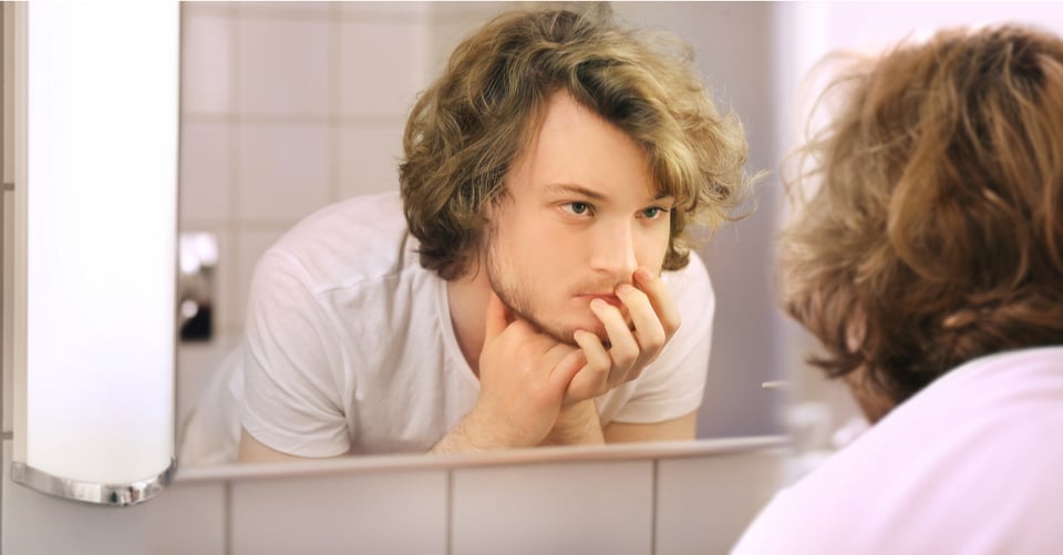 Joven en pubertad mirando espejo