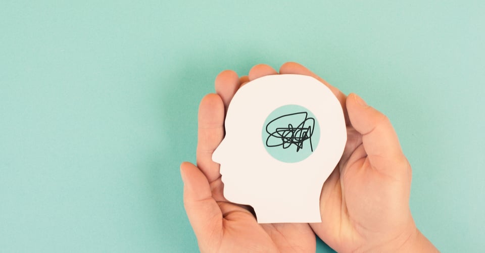 Las manos de un niño sujetando una cabeza de papel