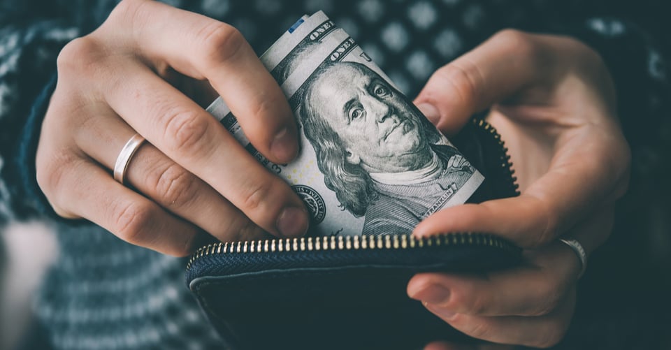 Persona metiendo dinero en su cartera
