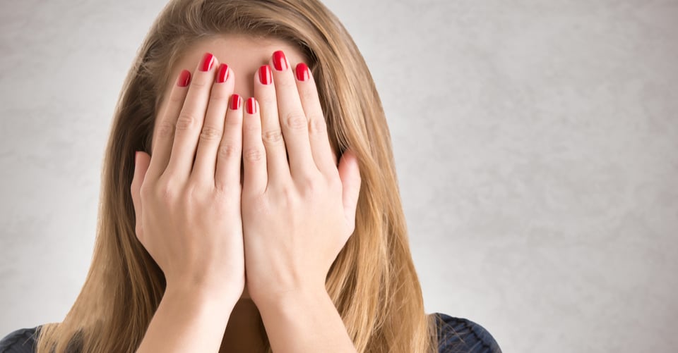 Una mamá cubriendo su rostro con sus manos