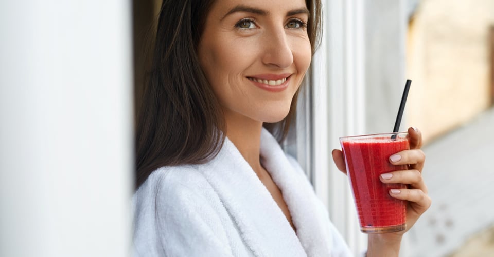 Una mujer con un jugo en la mano