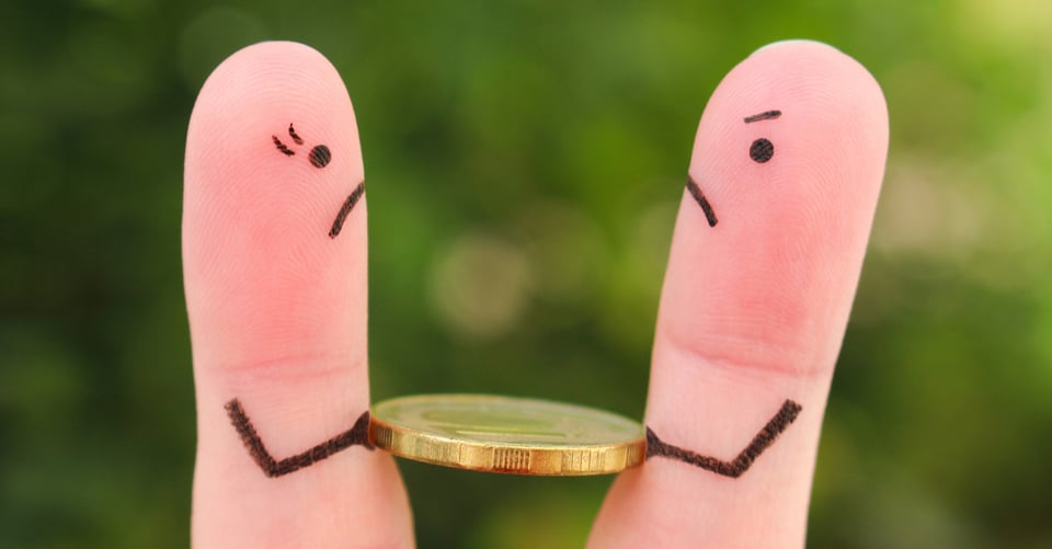 Dos dedos sujetando moneda como idea de pareja con riña